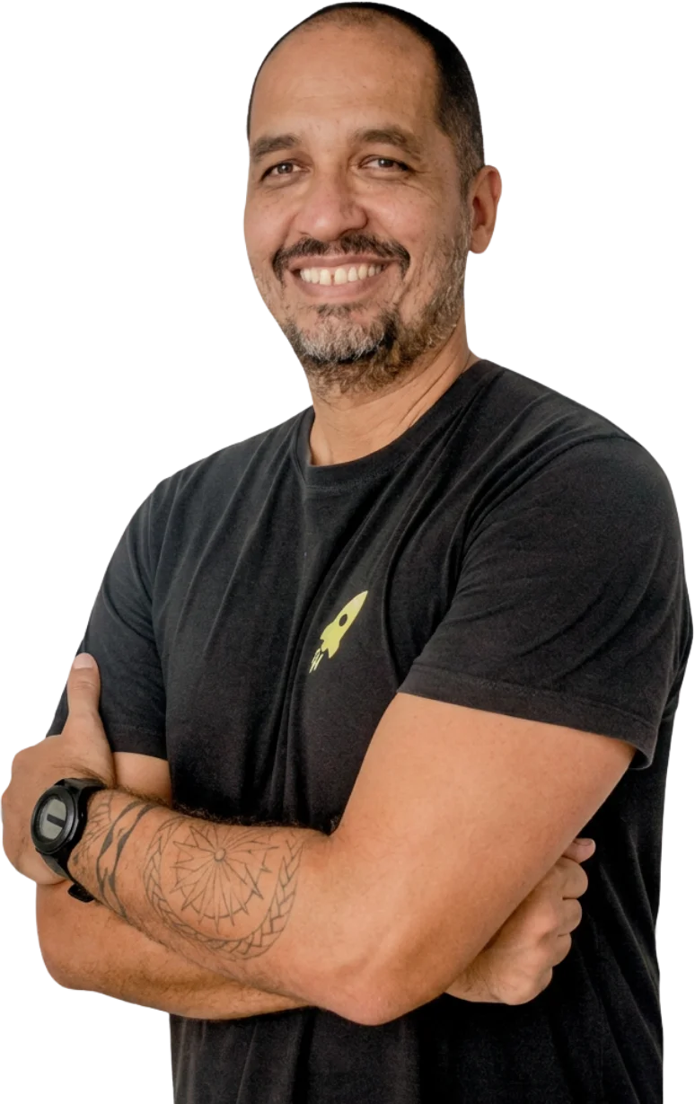 Professor Maico Soares, fundador do NEMAS, sorrindo de braços cruzados com camiseta preta do foguete
